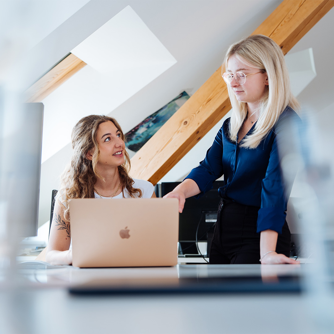 KG-177-1 Zwei Frauen im modernen Büro sprechen über die Google Ads Agentur.